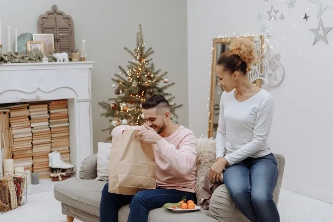 Mężczyzna i kobieta otwierają torbę z prezentem 