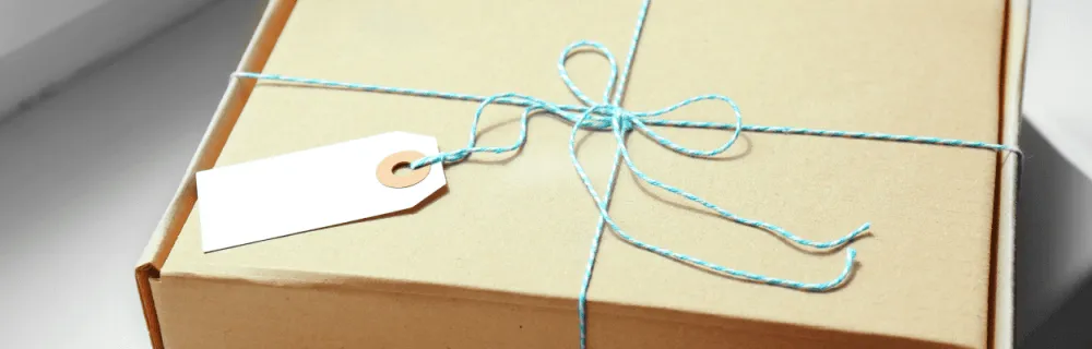 Karton wykrojnikowy przewiązany niebiesko-białą włóczką
