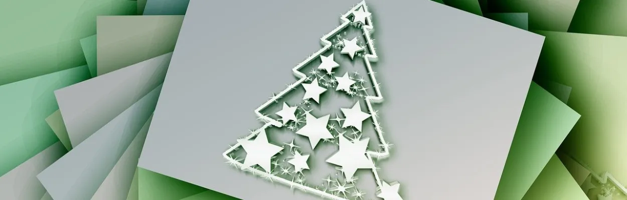 Kartka z życzeniami świątecznymi leżąca na stosie kopert w zielonym kolorze