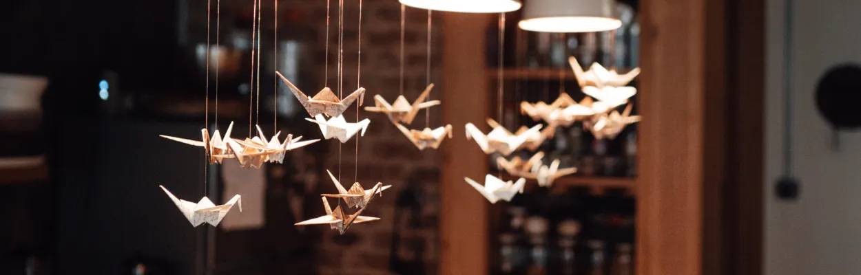Podwieszone pod lampami ptaki origami