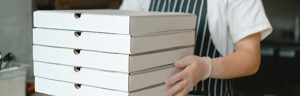 5 kartonów na pizzę trzymanych przez kucharza