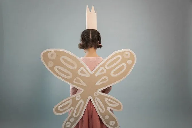 Dziewczynka w koronie z kartonu i ze skrzydłami